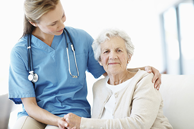 Elderly female patient holds her doctor's hand for reassurance